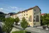 Textinsert: Foto Innsbruck, Egger-Lienz-Straße, Außenansicht Wohnbau, straßenseitig mit parkenden Autos und Bäumen