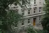 Textinsert: Foto Wien, Eisenbahnstraße, Außenansicht Wohnbau mit Eingangstür und Bäumen im Vordergrund