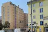 Textinsert: Foto Wien, Geiselbergstraße 38-42/Haufgasse 34, Außenansicht Wohnbau, straßenseitig mit Autos und Menschen im Vordergrund