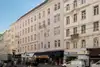 Textinsert: Foto Wien, Taborstraße 22 , Außenansicht Wohnbau, straßenseitig mit parkenden Autos, Geschäften und Menschen