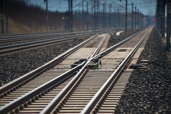 Track layout with switches, overhead line and signals in the background