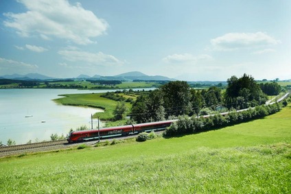 Railjet fährt neben See vorbei