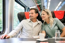 Mann und Frau sitzen im Railjet