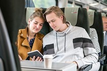 Junge Frau und junger Mann sitzen im Railjet