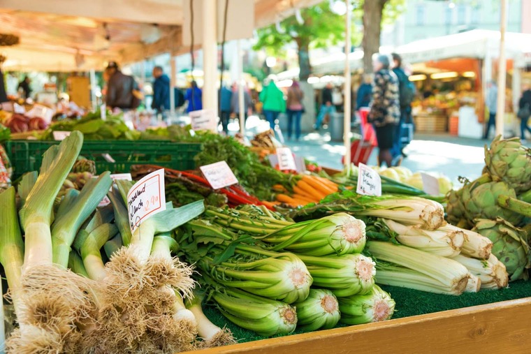 Sehenswürdigkeiten in München: Ein Blick auf einen Marktstand mit aufgestapeltem Gemüse am Viktualienmarkt