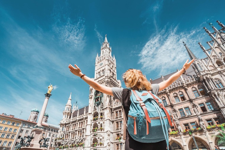Städtetrips Europa: Eine Frau mit Rucksack steht in der Münchner Innenstadt vor einem gotischen Gebäude