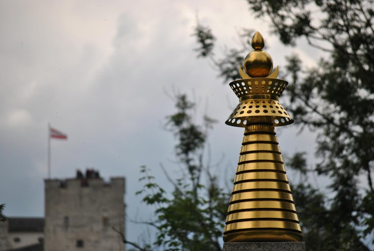 Ein Besuch der Stupa am Mönchsberg gehört zu den top Salzburg Geheimtipps. Man sieht über die goldene Spitze der Stupa die Salzburger Festung. 