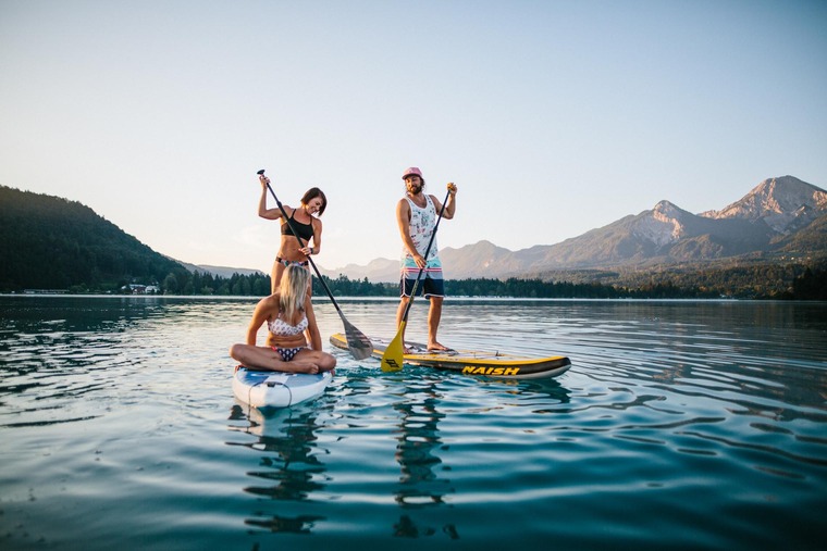 Urlaub in Kärnten: Mehrere Personen stehen auf dem Stand-up-Paddle am Faaker See