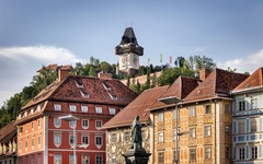 La Torre dell'Orologio di Graz con alcune case in primo piano