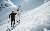 Zwei Personen warten auf der Piste