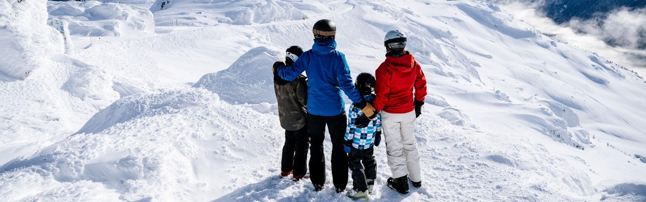 Familie am Berg mit Aussicht auf die Berge