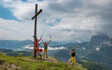 Familie unter Gipfelkreuz in der Region Kaiserwinkl