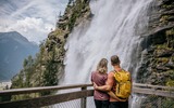 zwei Personen vor einem Wasserfall