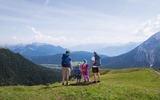 Familien-Weitwanderung im Gaistal - Familie steht auf Wiese mit Blick aufs Plateau Panorama