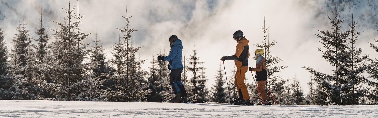 Familie vor Bergen mit Nebel (Skigebiet Berwang)