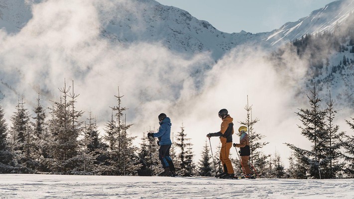 Familie vor Bergen mit Nebel (Skigebiet Berwang) 