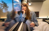 Donna in vagone letto che guarda sognante fuori dal finestrino