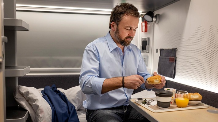 Reisender beim Frühstück im Schlafwagen comfort im Nightjet der neuen Generation