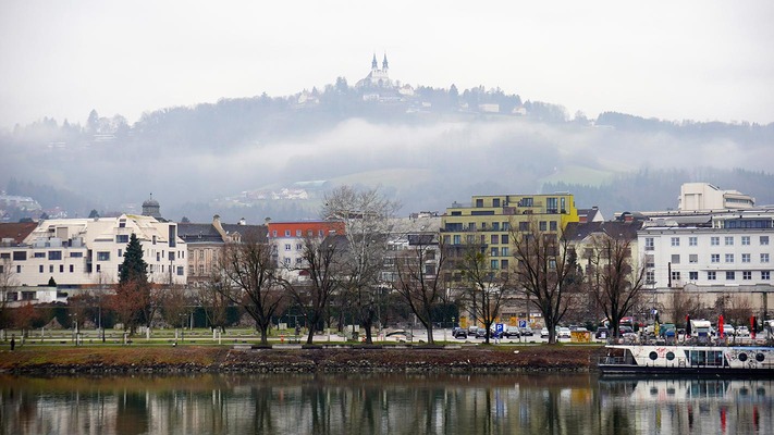 Linzer Old Town with a view from the Danube towards Pöstlingberg