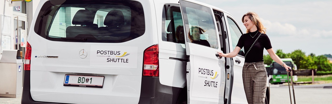 Frau steigt in Postbus Shuttle