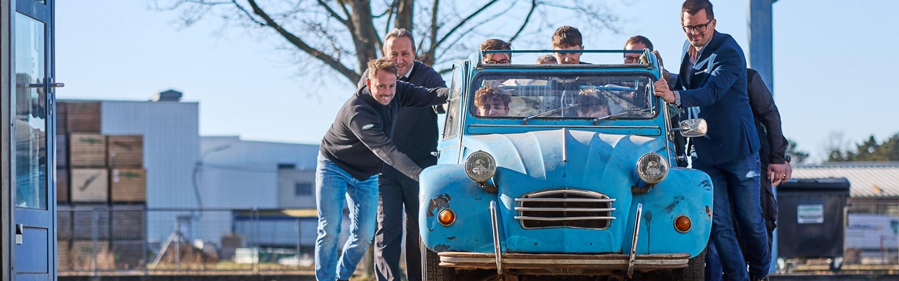 Personen schieben Oldtimer