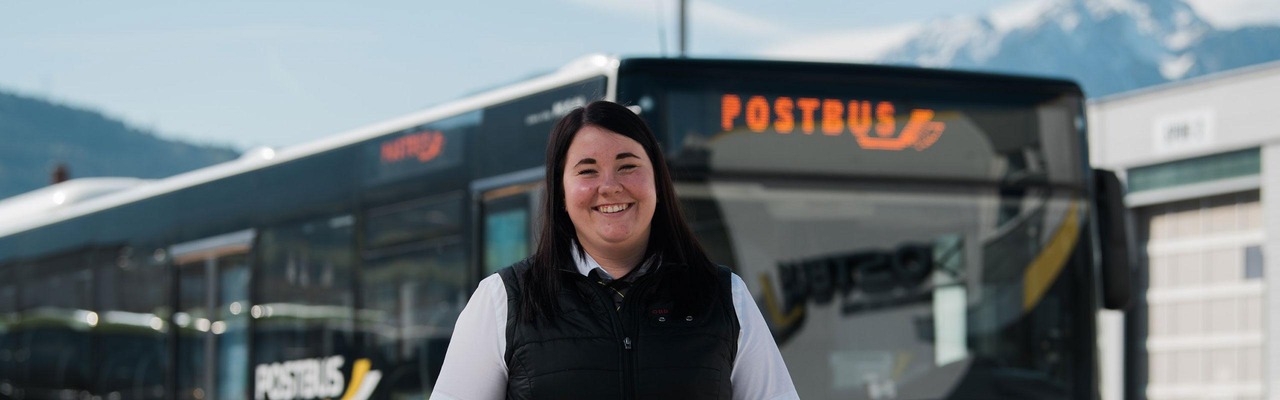 Mitarbeiterin steht vor Postbus