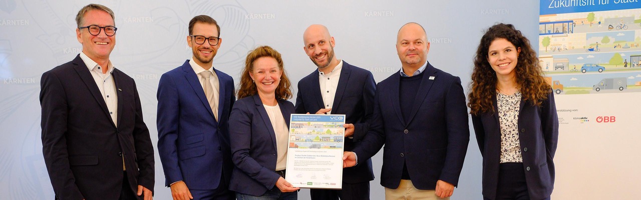 Personen halten Urkunde ins Bild