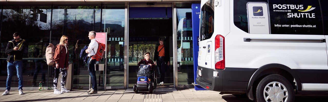 Personen stehen neben Postbus Shuttle