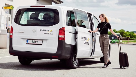 Frau steigt in Postbus Shuttle