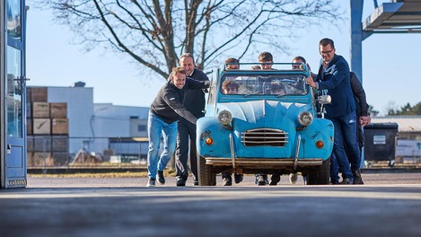 Personen schieben Oldtimer