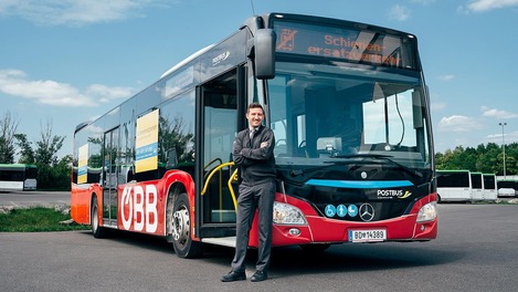 Bus driver in front of the new bus branding