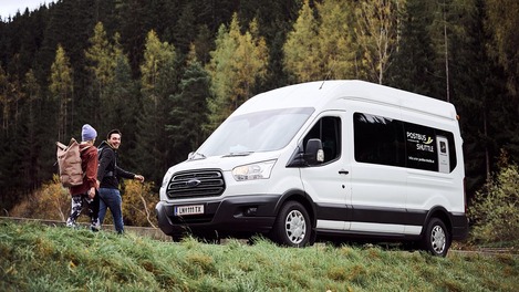 Paar steht vor Postbus Shuttle