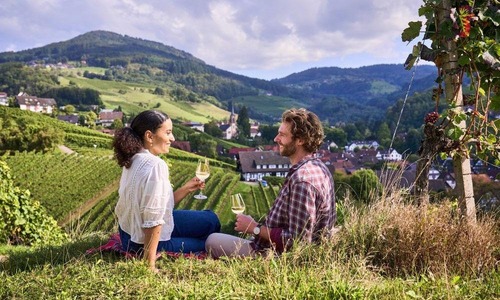 Ein Paar sitzt inmitten der Weinberge von Sasbachwalden und genießt ein Glas Wein © DZT/Jens Wegener Ein Paar sitzt inmitten der Weinberge von Sasbachwalden und genießt ein Glas Wein