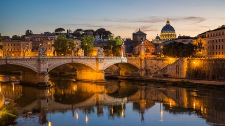 View of St Peter's Cathedral and the Tiber river from Pont Sant'Angelo at dusk