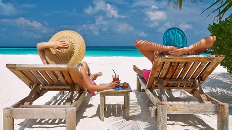 Ein Paar liegt auf Liegen im Sandstrand