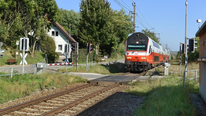 Cityjet Dosto fährt über Eisenbahnkreuzung