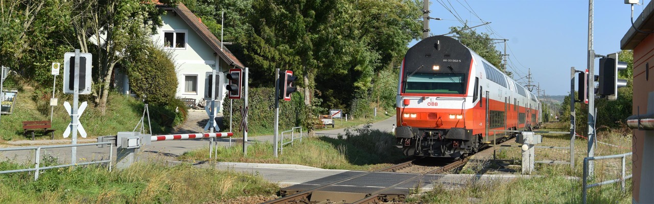 Cityjet Dosto fährt über Eisenbahnkreuzung