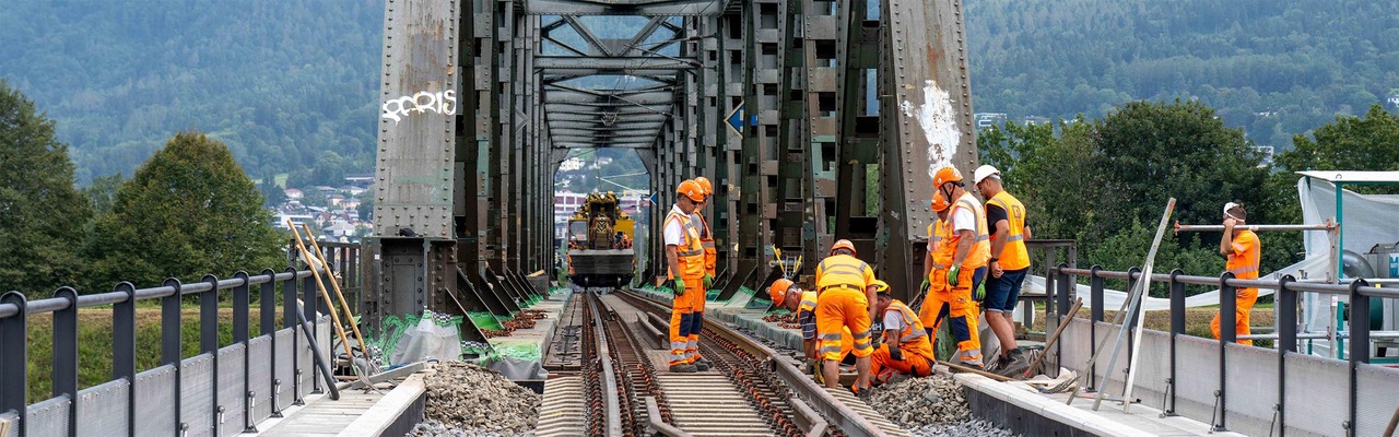 Bauarbeiter auf einer Brücke bei Gleisarbeiten