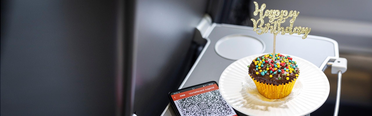 Geburtstagsmuffin & Handy mit ÖBB App auf Tablet im Zug