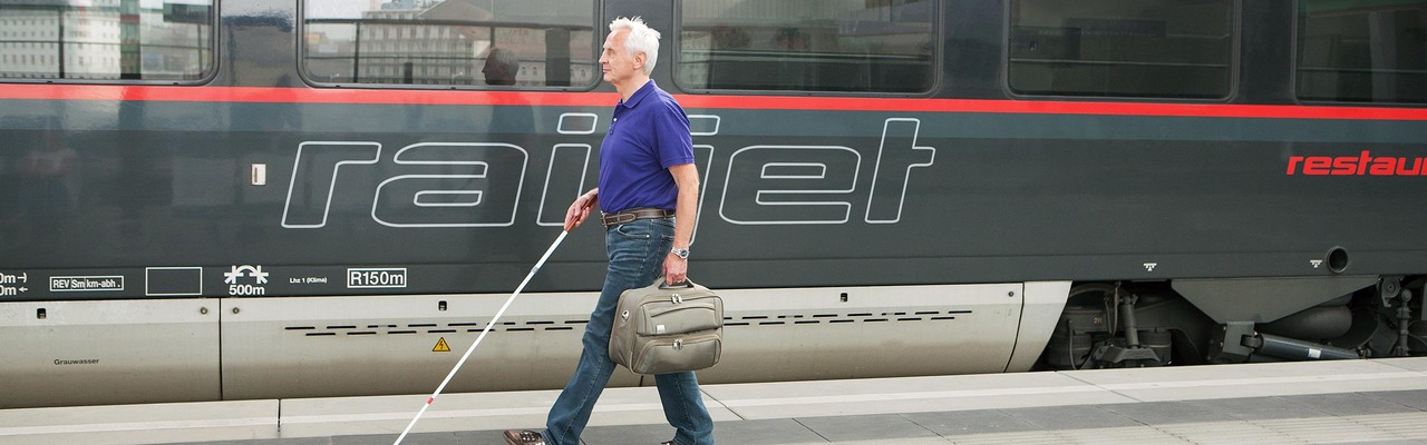 Sehbehinderter Fahrgast am Bahnsteig mit Blindenstock