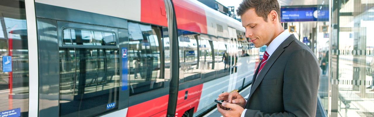 Businessreisender am Bahnsteig vor ÖBB Talent