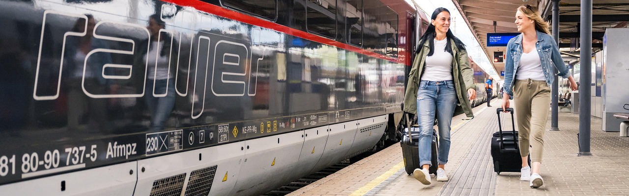 Reisende mit Gepäck am Bahnsteig