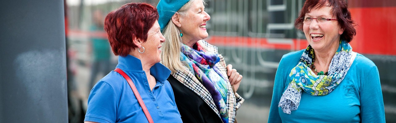 Three senior women on the platform in front of ÖBB Railjet