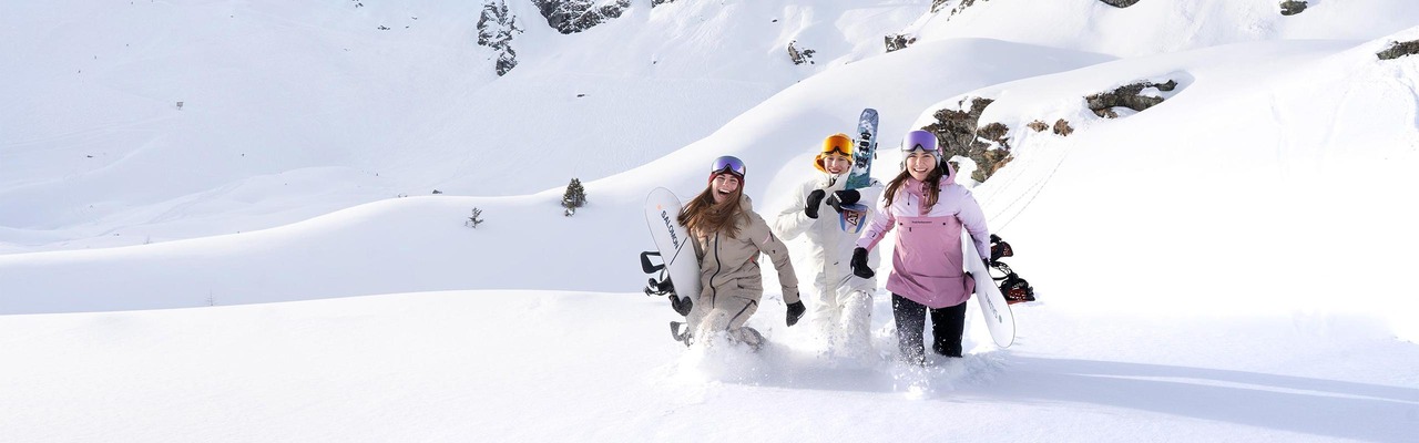 Skifahrer stehen auf Berggipfel und bewundern den Sonnenaufgang
