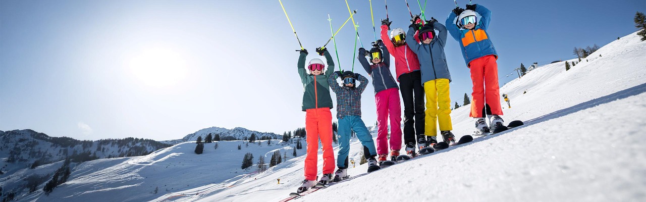 Skifahrer auf Piste vor Bergpanorama