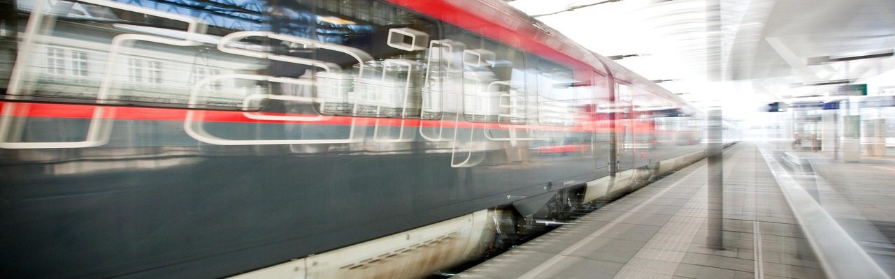 Railjet fährt durch Bahnhof