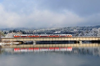 Cityjet fährt über Brücke in Schneelandschaft