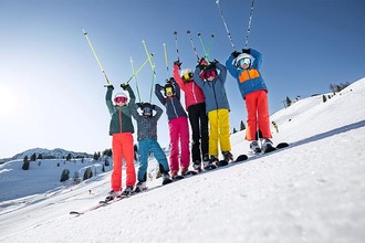 Skifahrer auf Piste vor Bergpanorama