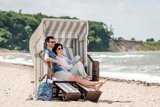 Paar entspannt im Strandkorb auf dem Ostseestrand