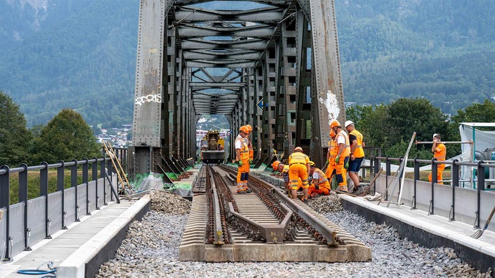 Bauarbeiter auf einer Brücke bei Gleisarbeiten